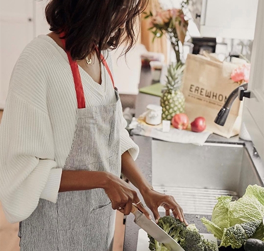 Broadcast Center Apartments - Los Angeles, CA - Person cutting vegetables in kitchen