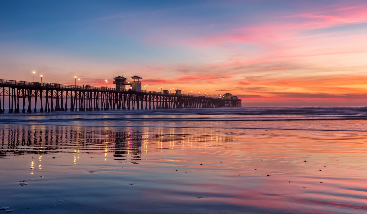 Island Club Apartments in Oceanside, CA - Oceanside Pier at dusk. .<p style="text-align: center;">&nbsp;</p>
<p style="text-align: center;">Evening strolls at the Oceanside Pier are just a 16-minute drive from home.&nbsp;</p>
