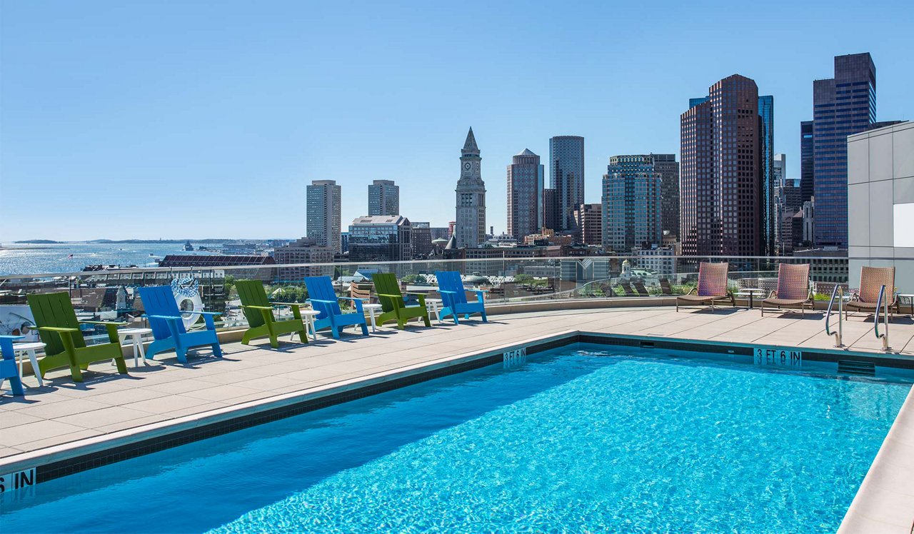 One Canal pool deck with chairs and the boston city skyline in the background