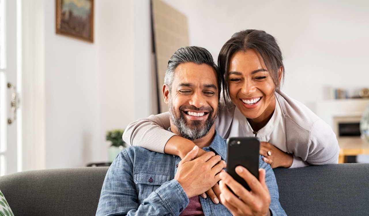 Southgate Towers - Miami, Fl - Couple looking at phone in living room