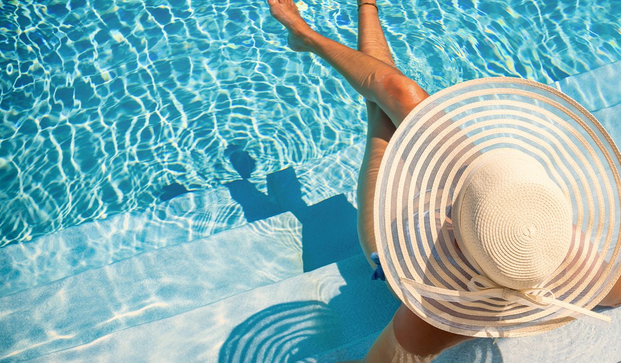 Woman in pool with big hat