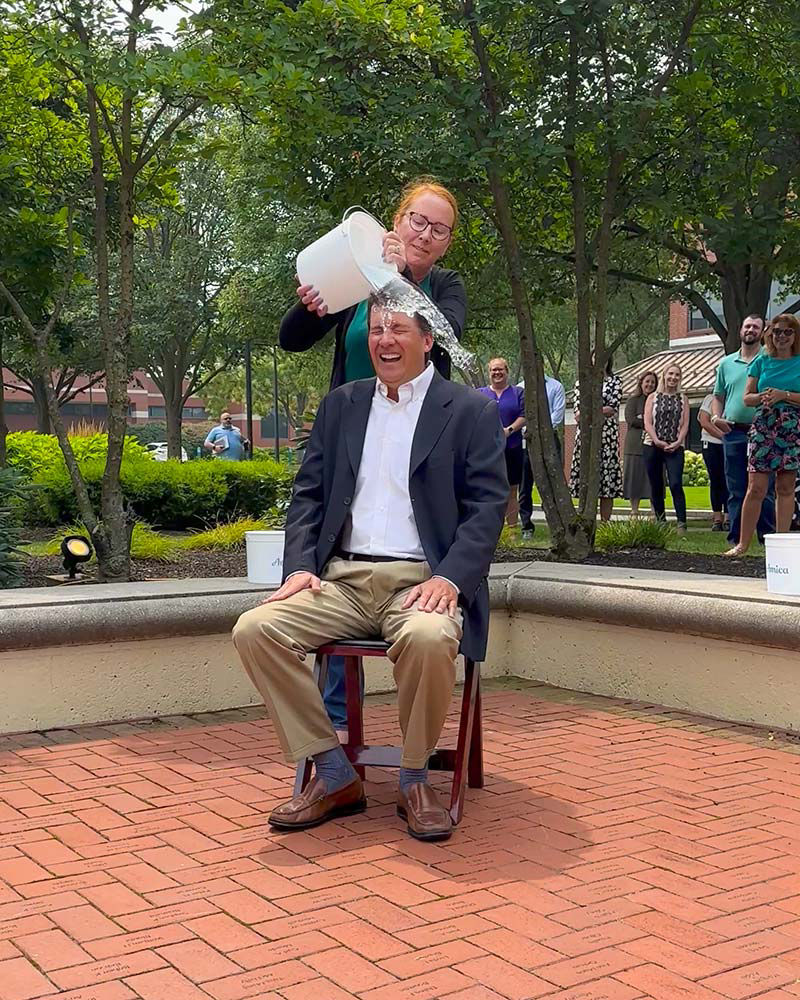 Amica President and CEO Ted Shallcross gets doused with water by employee Rachel Jones