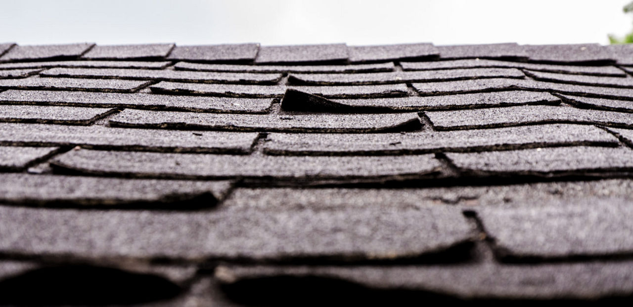 An old roof with lifting shingles.