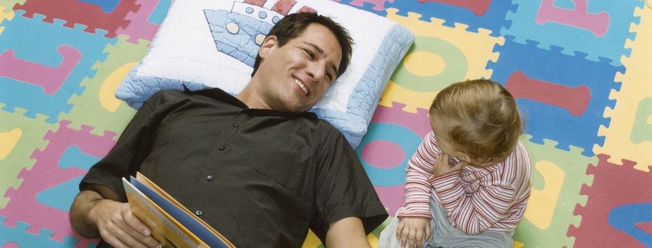 A father and child on a cushioned play floor.