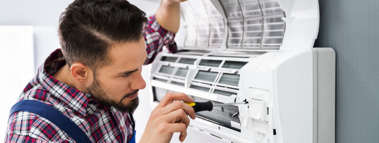 A person working on an air conditioner. 