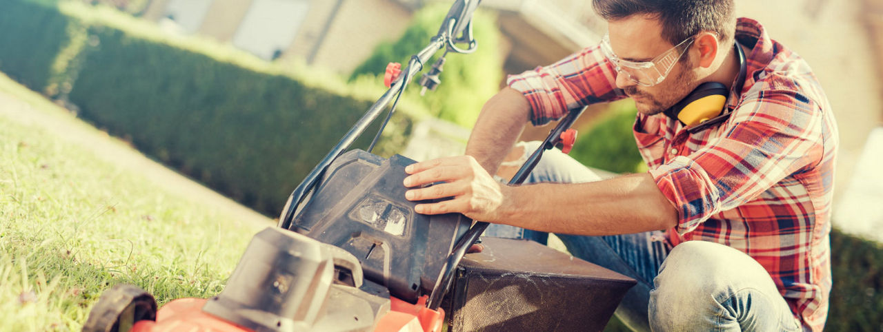 A person working on a lawnmower. 