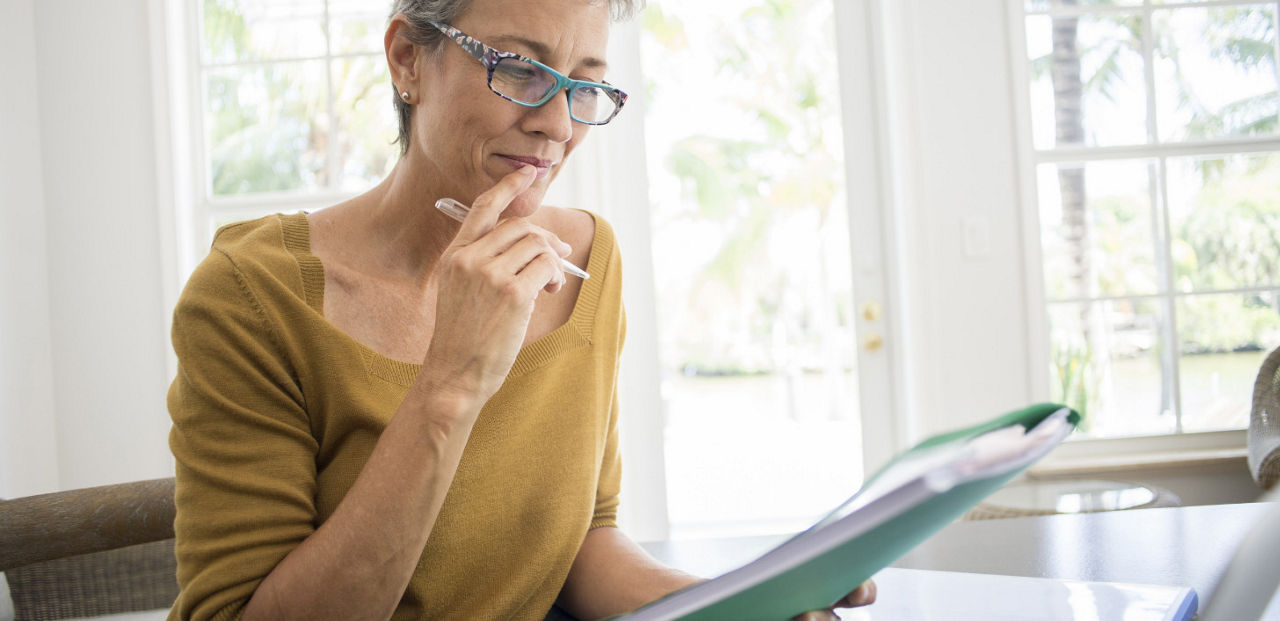 Woman looking at a notebook thinking.