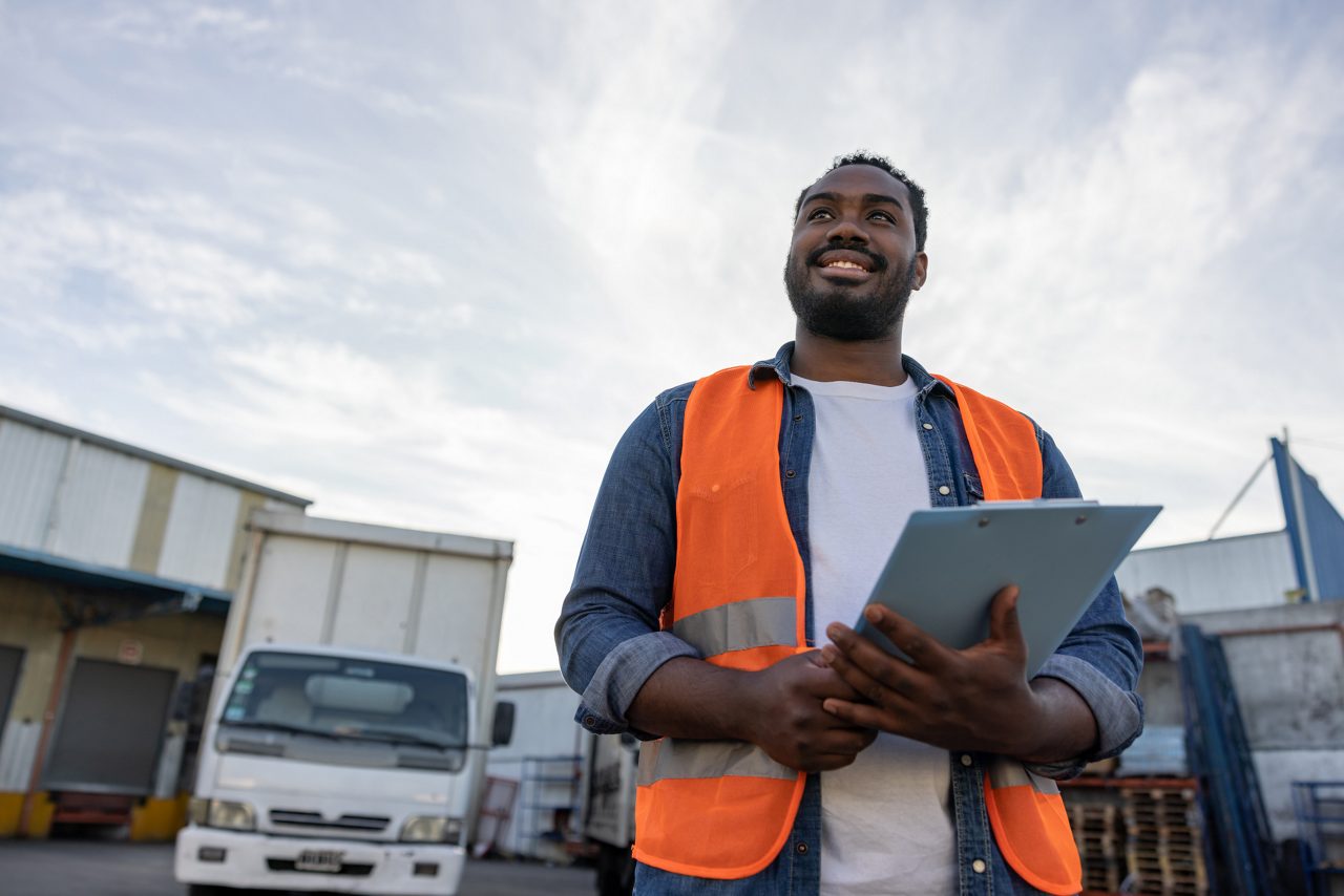 Portrait of a happy African American truck driver getting ready for his next drive - freight transportation concepts