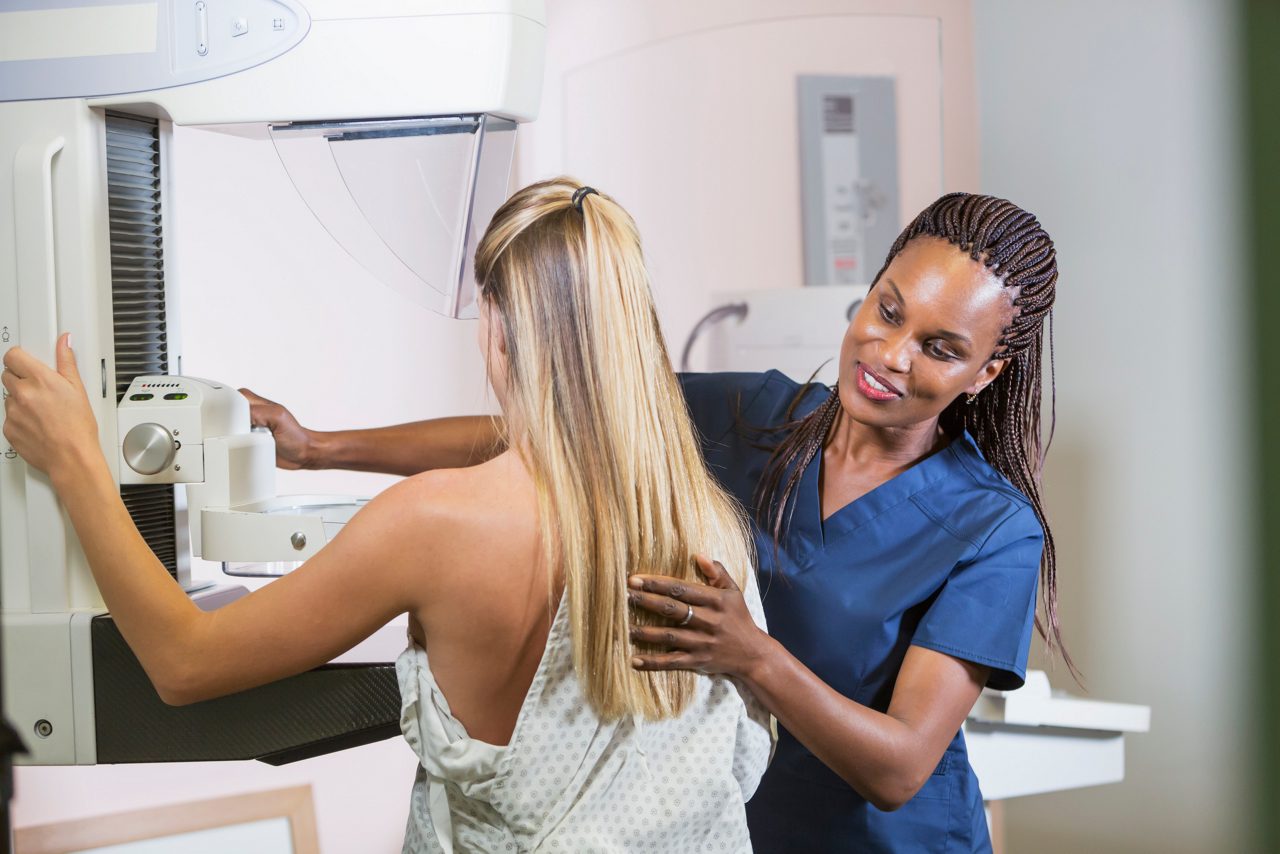 Doctor helping patient into diagnostic machine