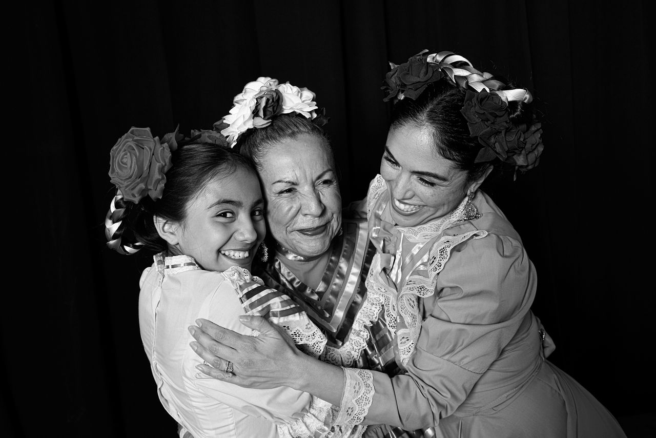 Grandmother, mother, and daughter hugging