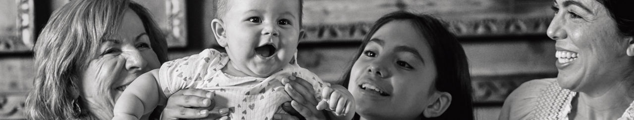  Smiling grandmother, sister, and mother with baby