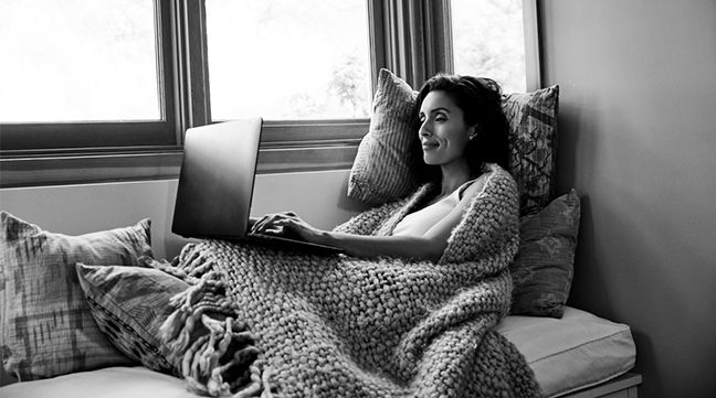 mujer en el sofá con la computadora portátil
