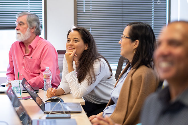 4 coworkers at table at meeting, 2 men, 2 women