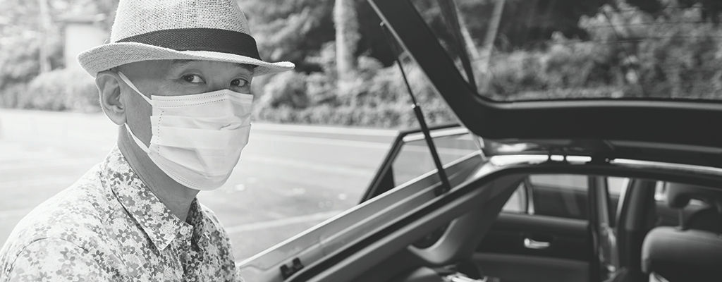 Man in car wearing mask