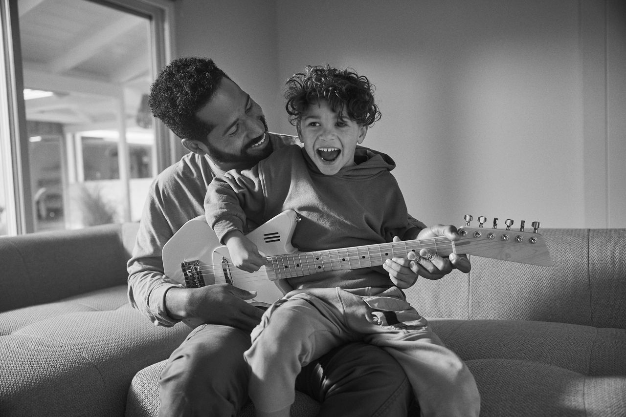 image of father and child playing guitar