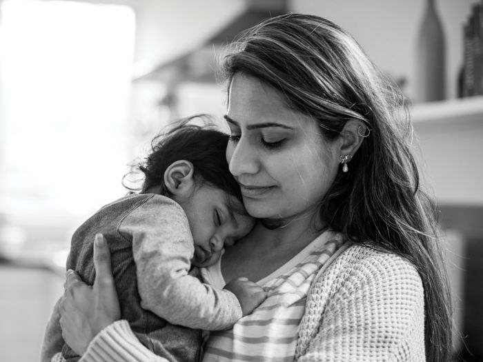 Mother with toddler asleep on her shoulder