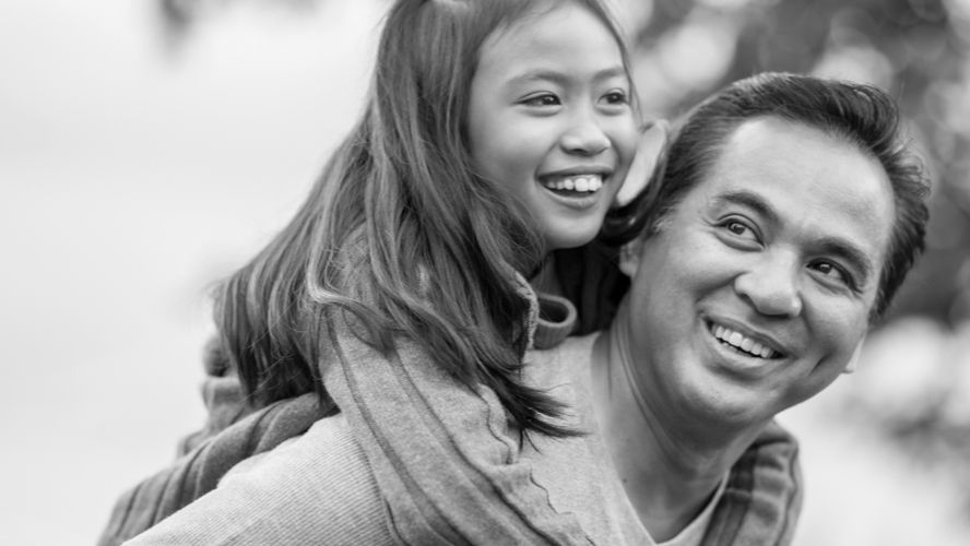 Father carrying daughter and smiling