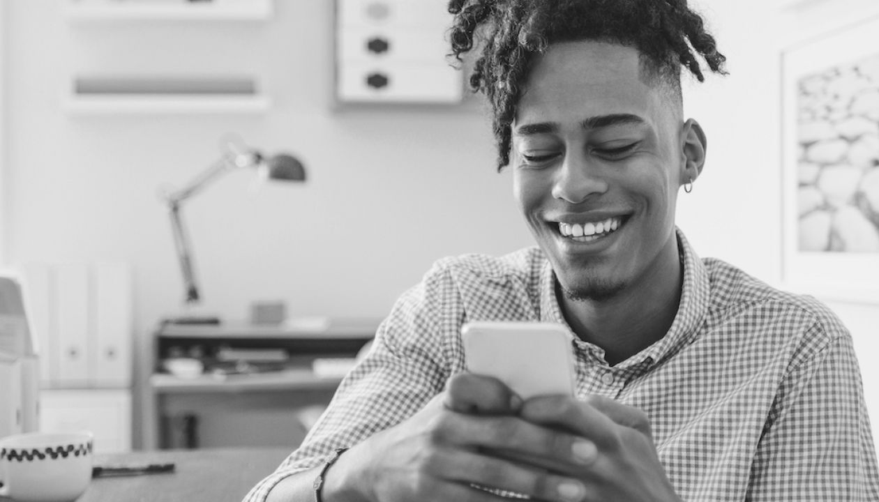 Man smiling and holding his phone