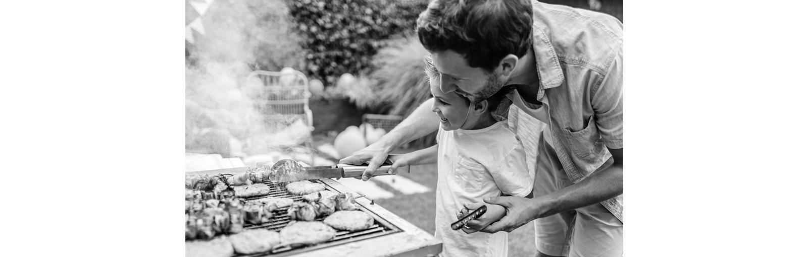 Father teaching child how to grill