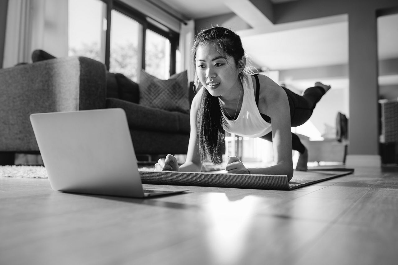 Woman looking at laptop with one leg raised