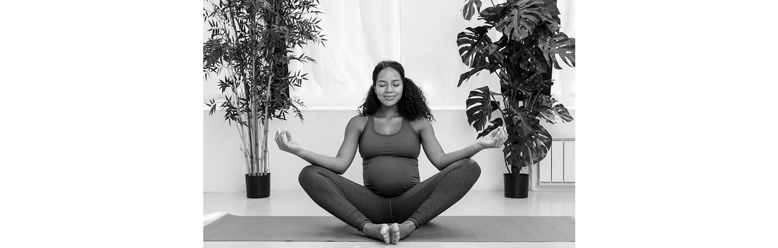 Pregnant woman indoors meditating with eyes closed in lotus pose
1085205786