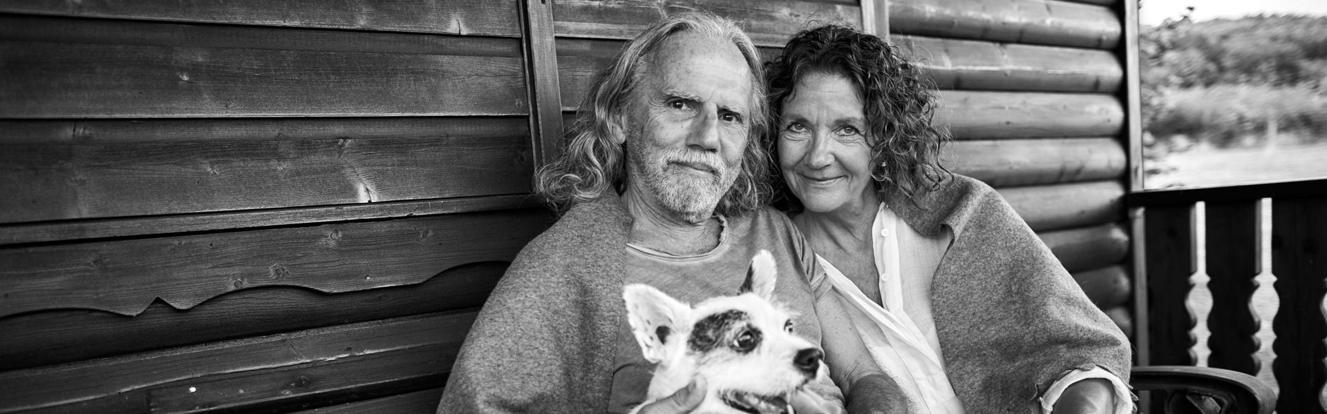 Senior couple with dog on cabin porch