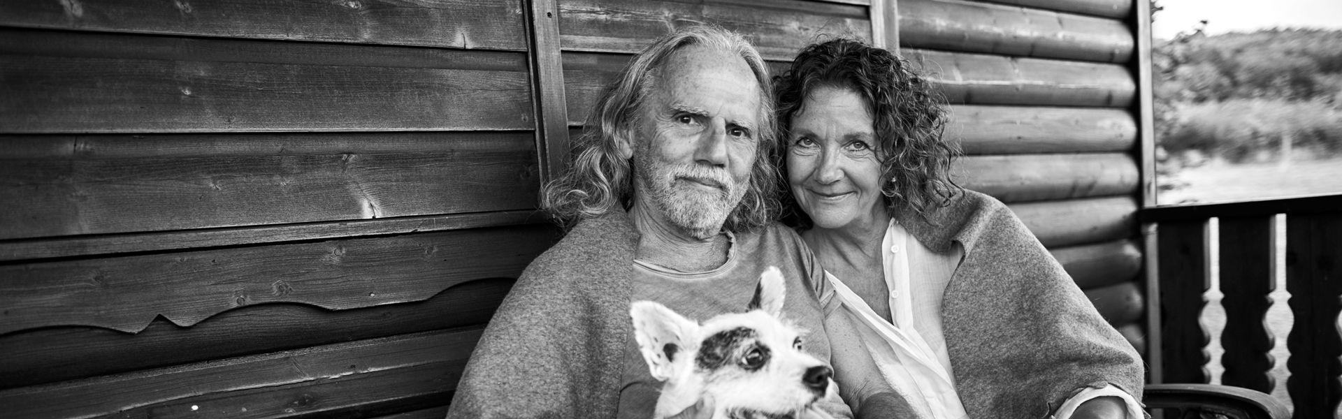 Senior couple with dog on cabin porch