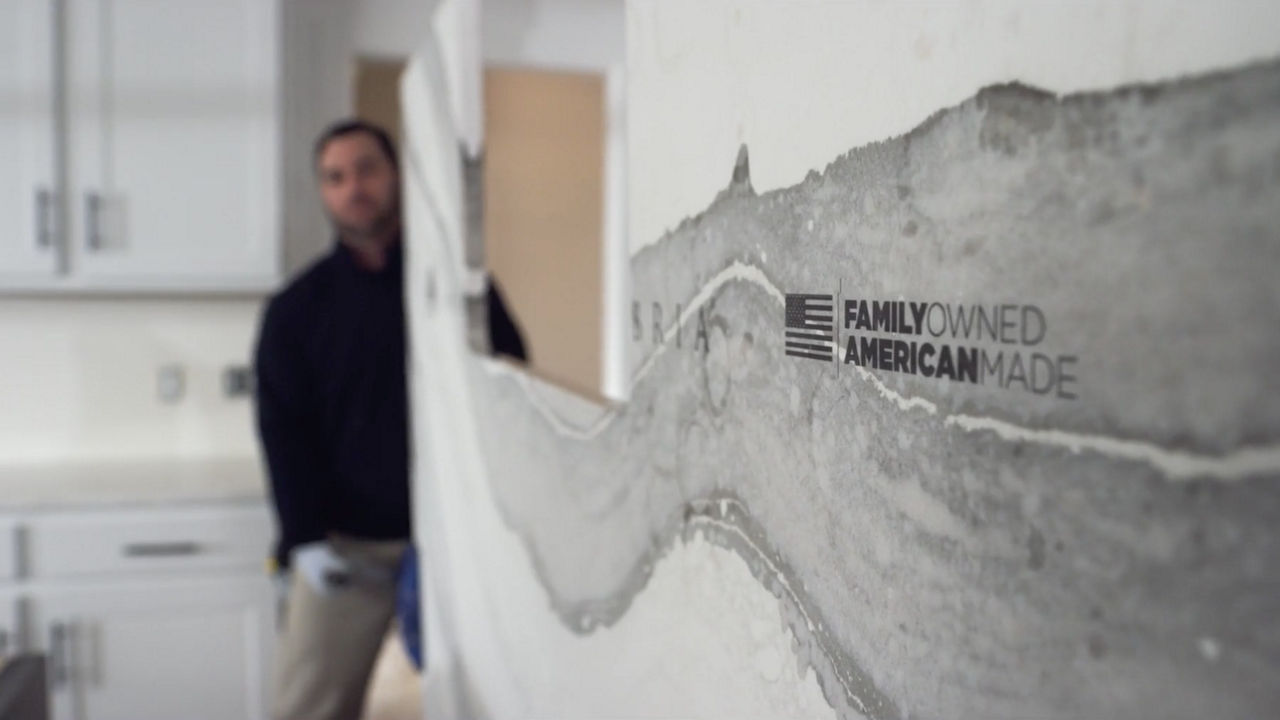 A Cambria employee installing a slab of quartz countertops.