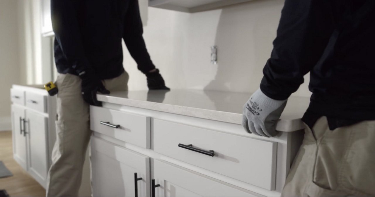 two Cambria employees installing a quartz countertop.