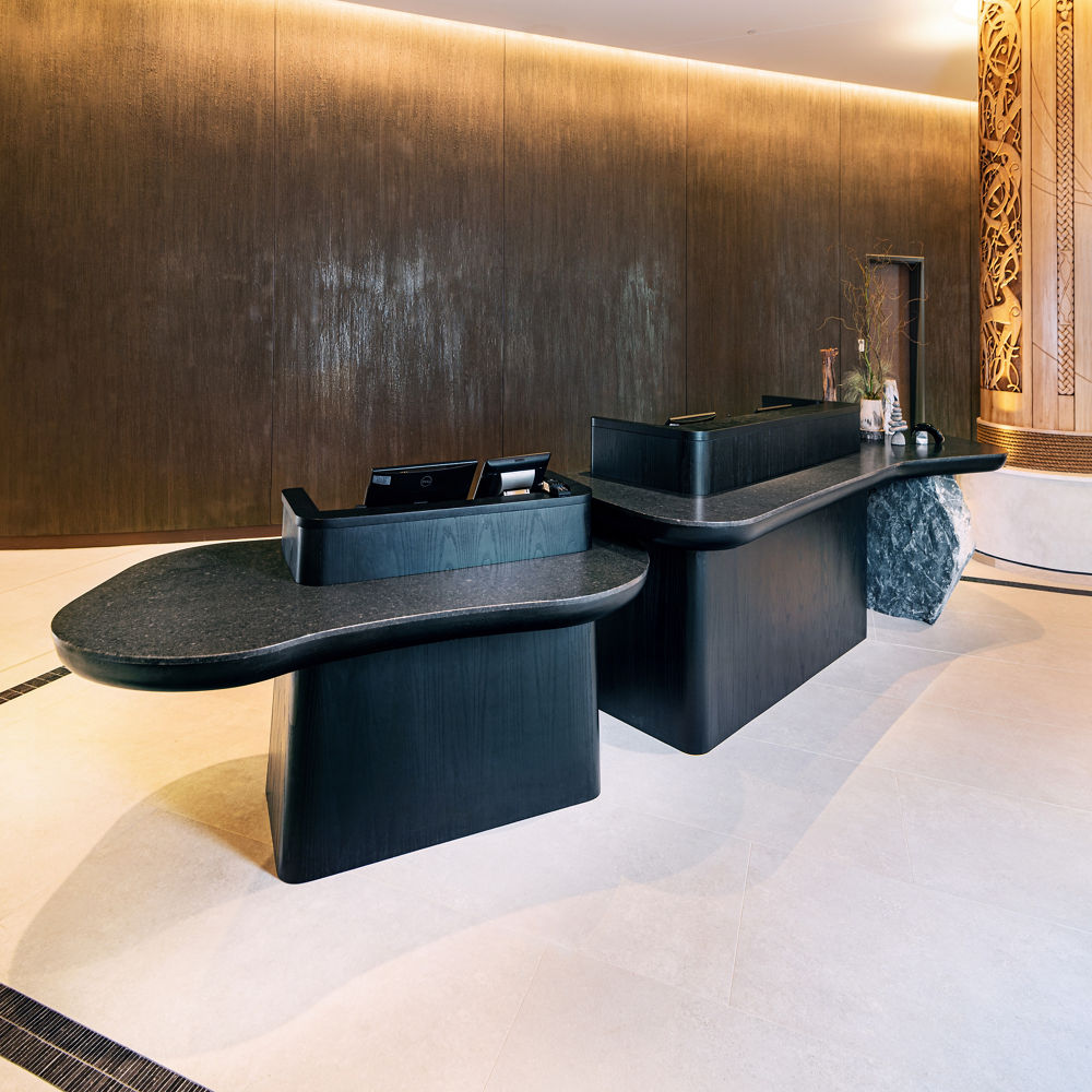 A lobby island and reception desk featuring Cambria Durham Matte quartz countertops.