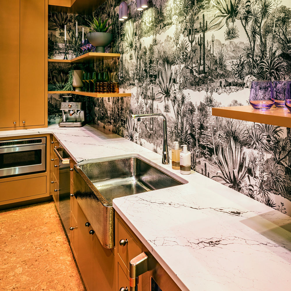 An eclectic kitchen design with Cambria Inverness Platinum quartz countertops and a stainless steel farmhouse sink