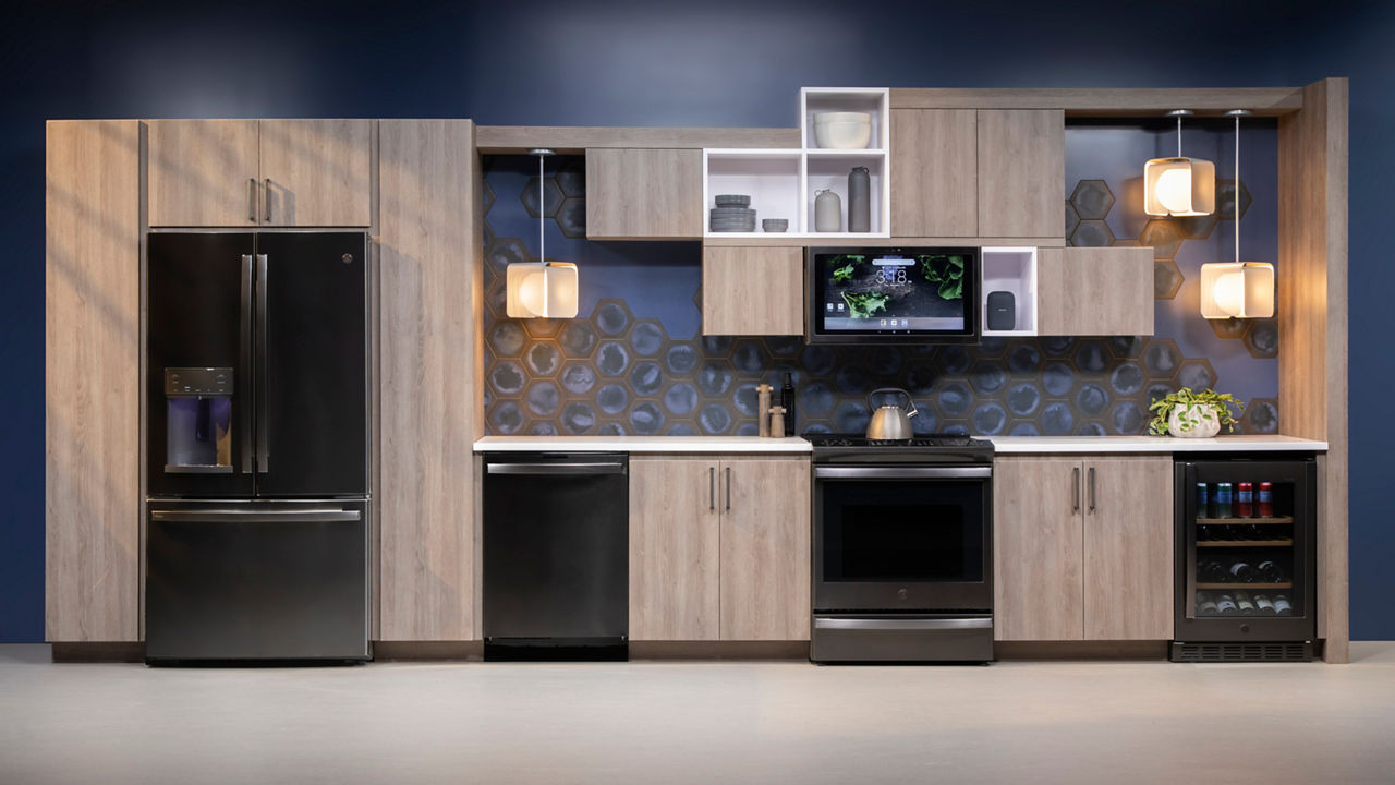 a futuristic kitchen with navy wall paint, wooden cabinets, black appliances, white quartz countertops, and modern upper cabinets with open box shelving and cubical hanging lights. 