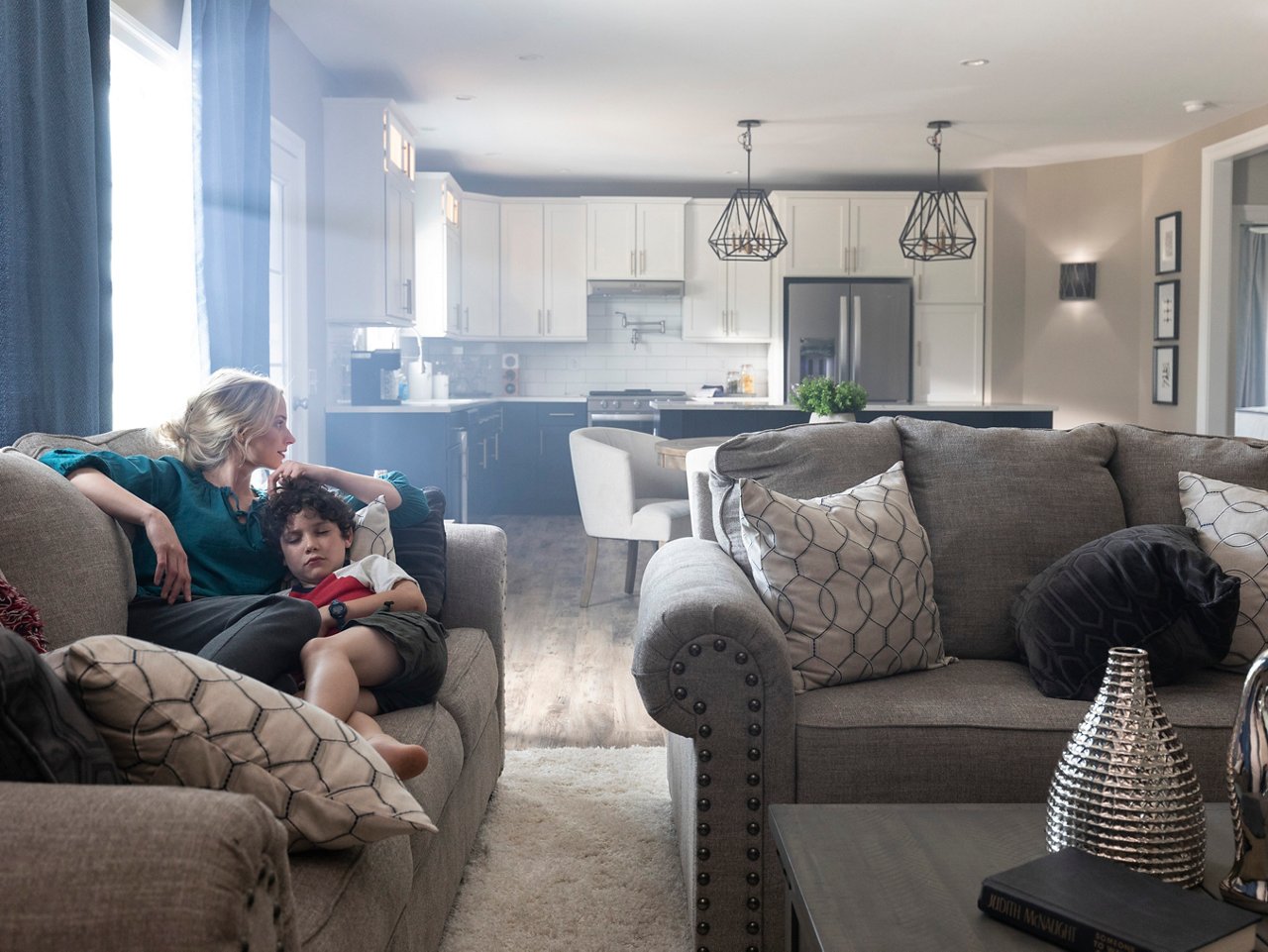 Woman relaxes on the couch with her child in the comfort of her Champion home