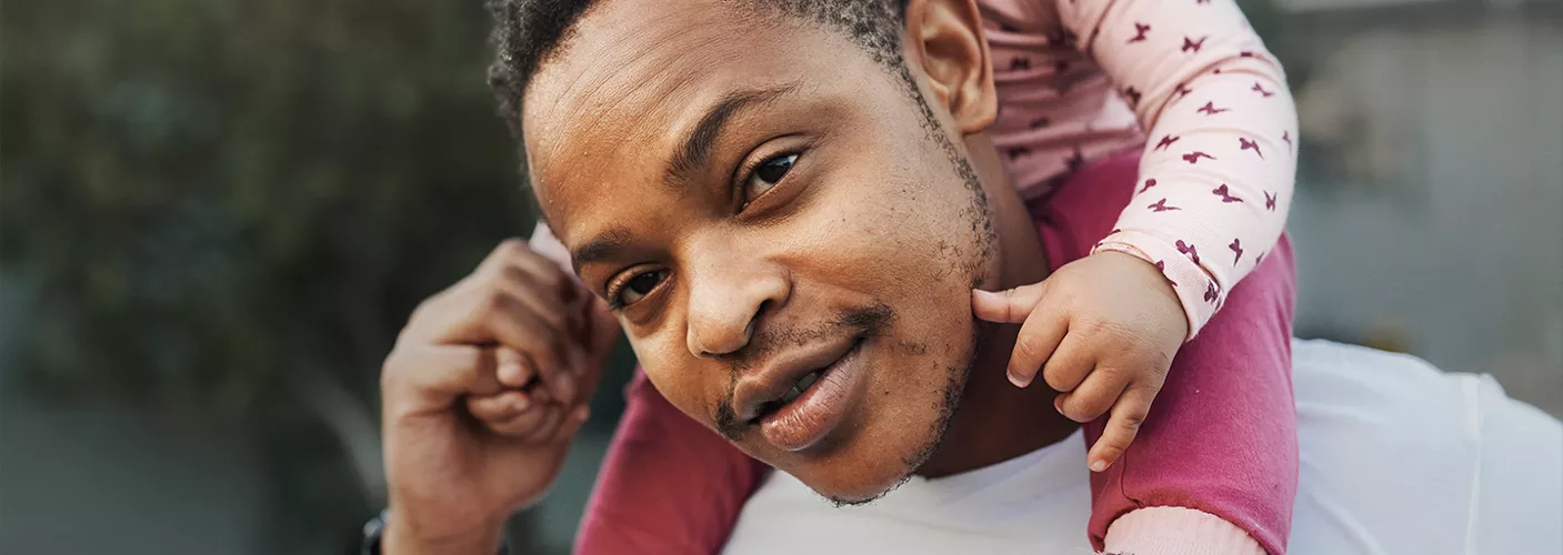 Person holding a child on their shoulders