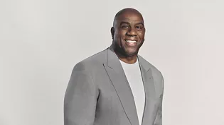 Mr. Earvin "Magic" Johnson, smiling in front of a plain background.