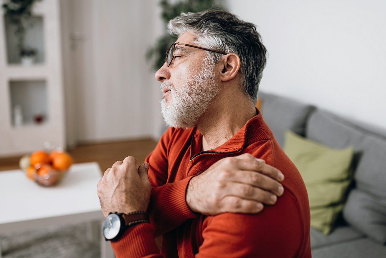man rubbing his shoulder to relieve pain