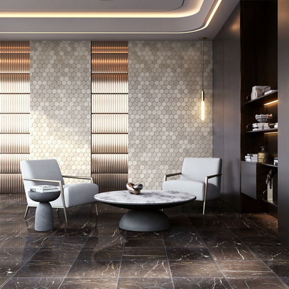 Lounge space with beige hexagon stone look mosaic tile on back wall, brown marble look floor tile, two white chairs, marble coffee table, and gold accents.