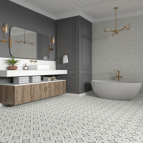 Bathroom with gray back wall, wood cabinets, white countertop, white tub, and white encaustic floor tile.