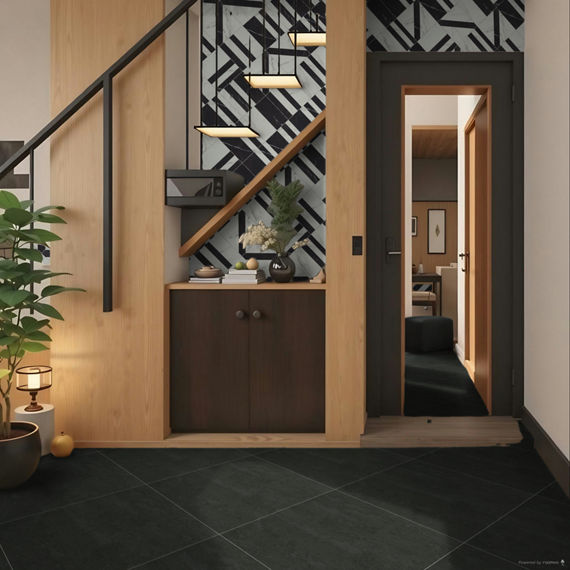 Cupboard under the stairs with black stone look square floor tile, white and black wall tile, brown cabinet, and bookstack on cabinet.