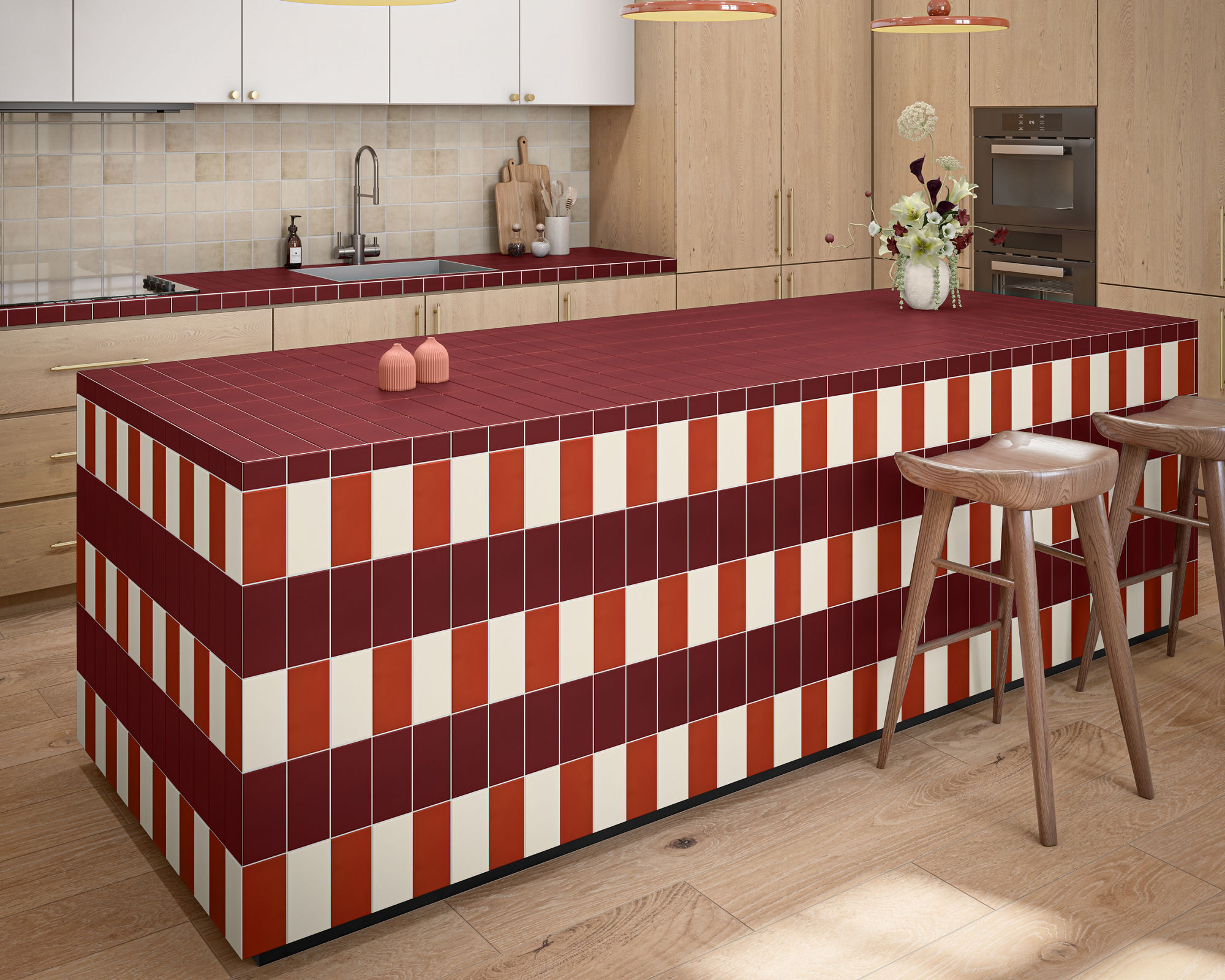 Contemporary kitchen interior featuring a bold striped island covered in red, orange, and cream tiles. Light wood cabinetry and flooring create a warm, minimalist backdrop. A sleek faucet, built-in oven, and cooktop emphasize the modern design. Penda