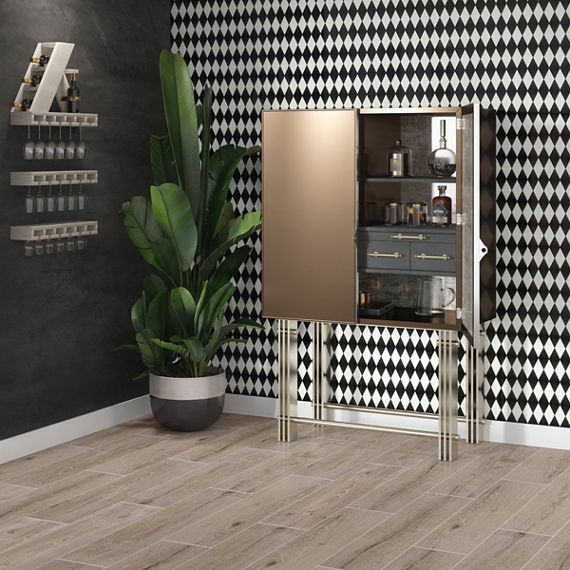 Golden bar cart with various bottles, black and white harlequin wall tile, black side wall, and wood look floor tile.