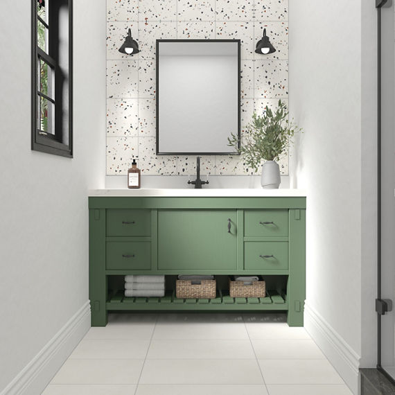 Bathroom sink with green cabinets, white countertop, white terrazzo look rectangle tile on back wall, white walls, and white rectangle concrete look floor tile.
