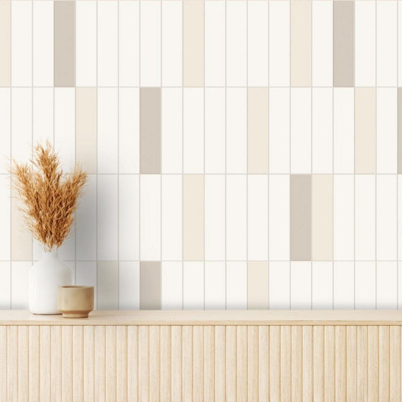 Close up of wall with white and beige subway tile, wooden table, and small plant on wooden table.