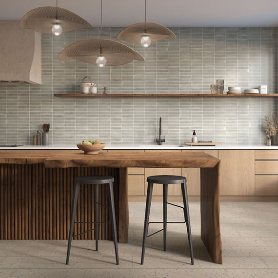 Kitchen with wood island, wood cabinets, and gray subway tile on backsplash.