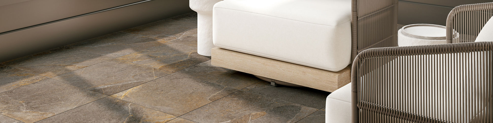 Sitting area with brown rectangle stone look floor tile, large windows, and two white chairs.