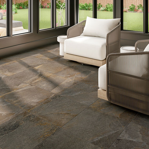 Sitting area with brown rectangle stone look floor tile, large windows, and two white chairs.