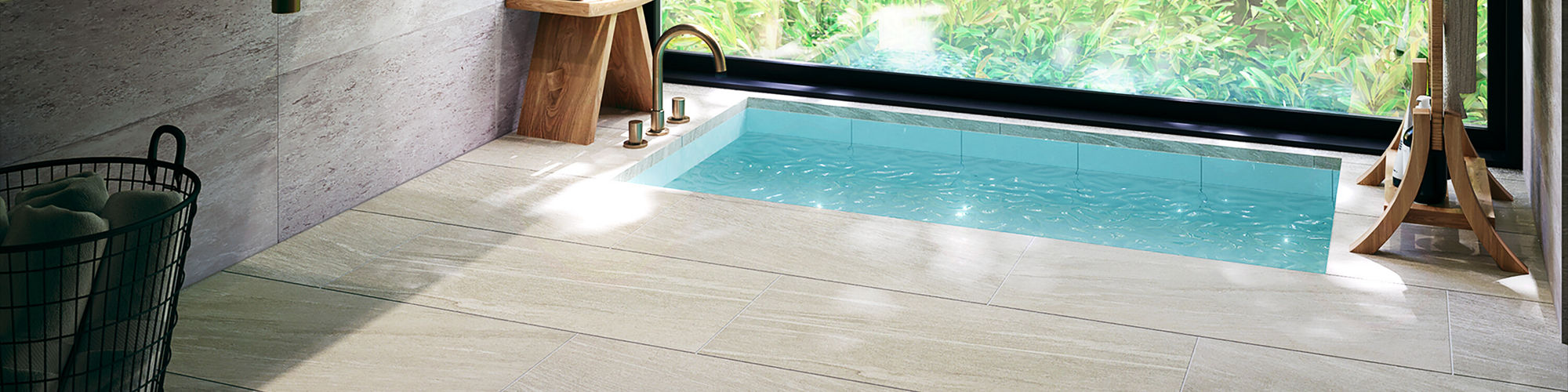 Bathroom with large window wall showing greenery, gray rectangle stone look wall tile, an in floor bathtub, circle mirror, and light gray rectangle stone look floor tile.