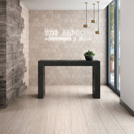 Boutique and spa entry table with beige stone look rectangle floor tile, beige hexagon stone look tile on back wall, and wood look tile on side wall.