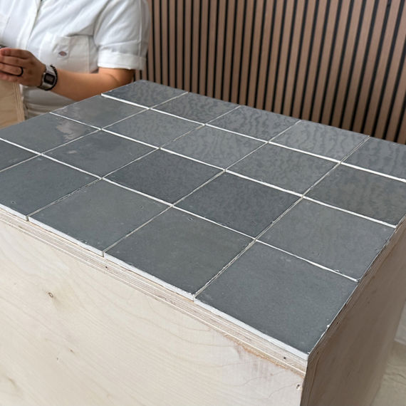 Gray square tile placed onto table to test out layout.