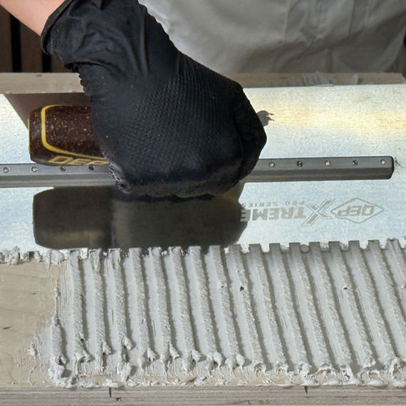 Thinset being placed on wooden table base.